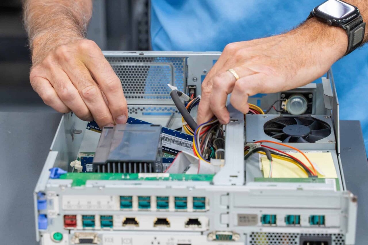 Technician adjusting components in a computer, ensuring technology support and efficiency.