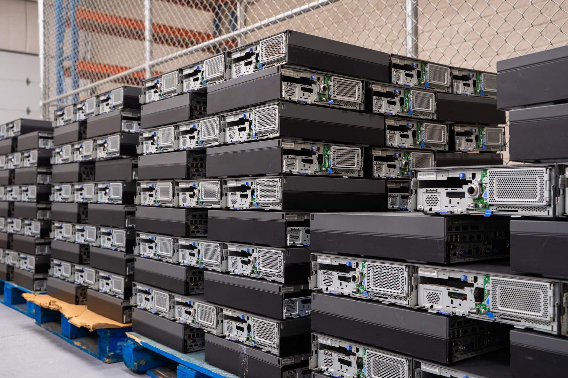 Stacks of computer units on pallets ready for IT asset disposition during store closures without risk.