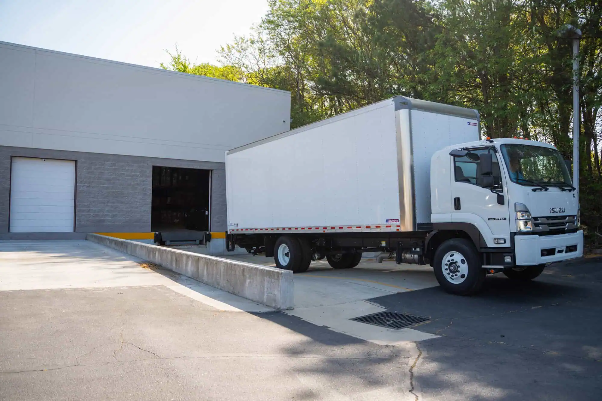 White delivery truck parked at a loading dock, highlighting secure destruction as assets leave your site.