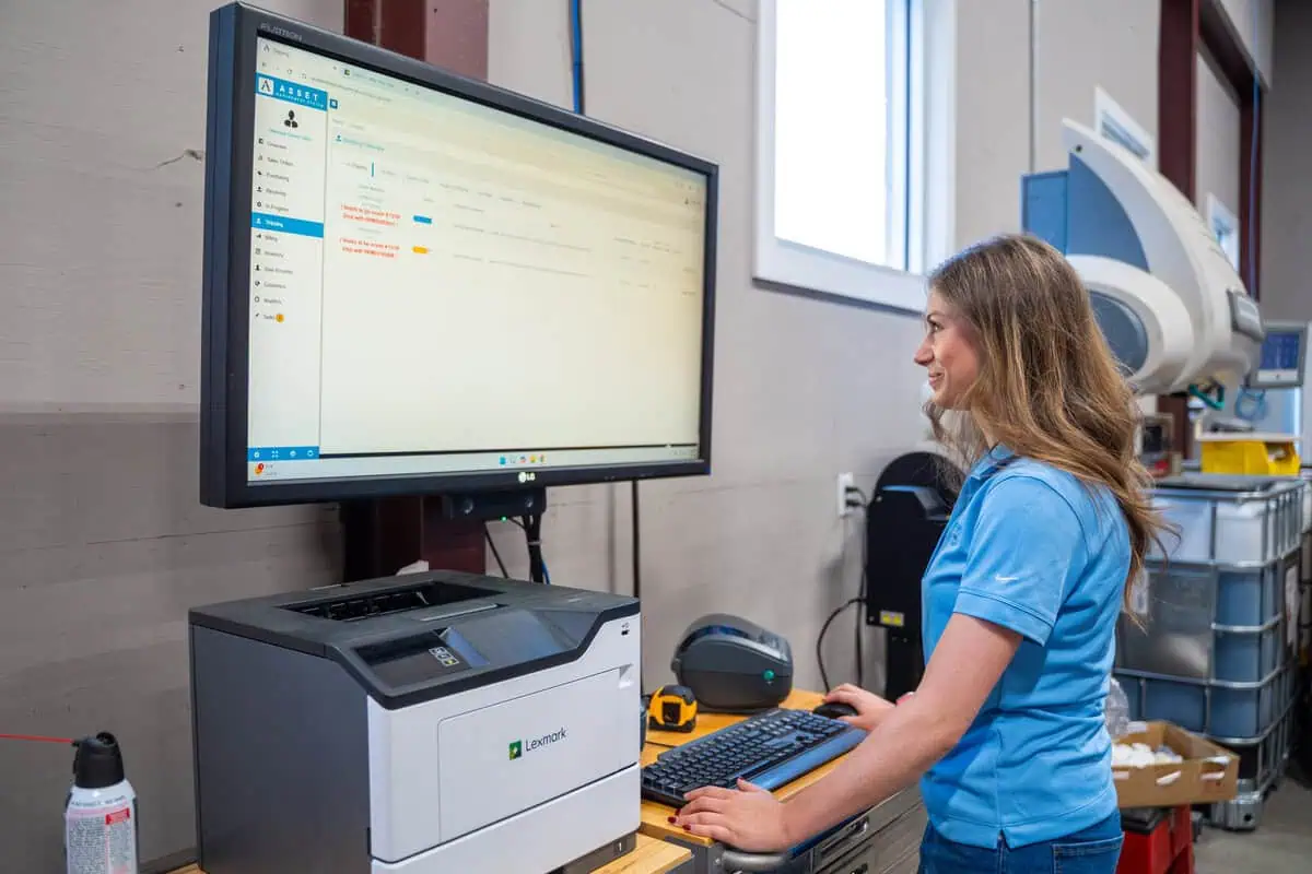 Our experienced team member at a computer, optimizing services integration kitting process design.